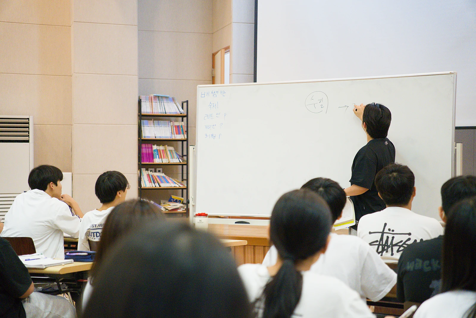 닥공캠프 국내캠프 수업 — 칠판 앞에서 설명하는 선생님과 자리에 앉아 수업을 듣는 학생들