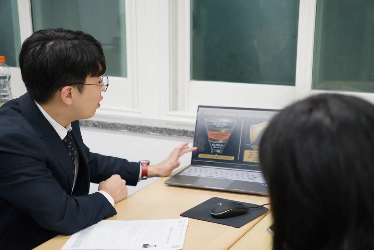 컨설턴트가 노트북 화면 자료를 짚어 가며 상담하는 모습